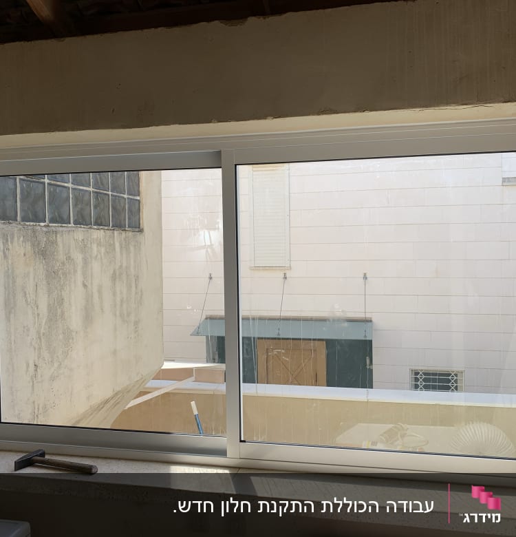 חלון אלומיניום עם מסגרת לבנה וידית